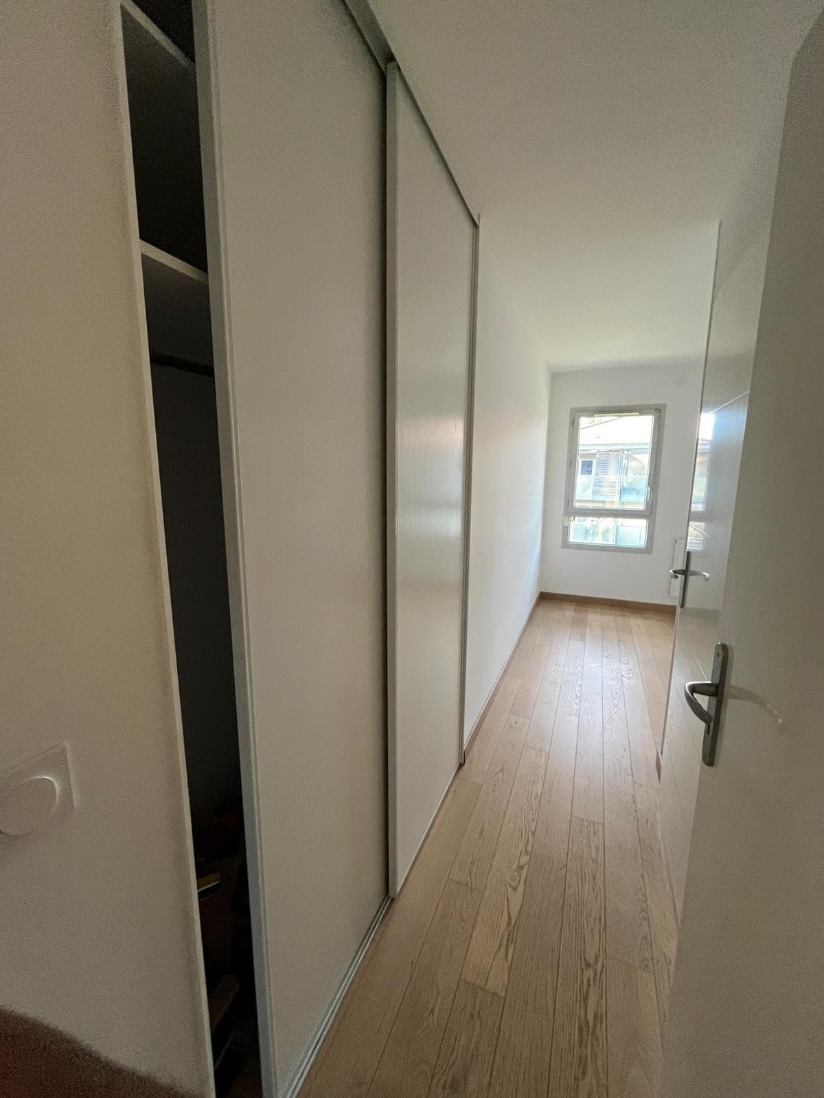 Couloir avec grands placards coulissants et parquet chêne