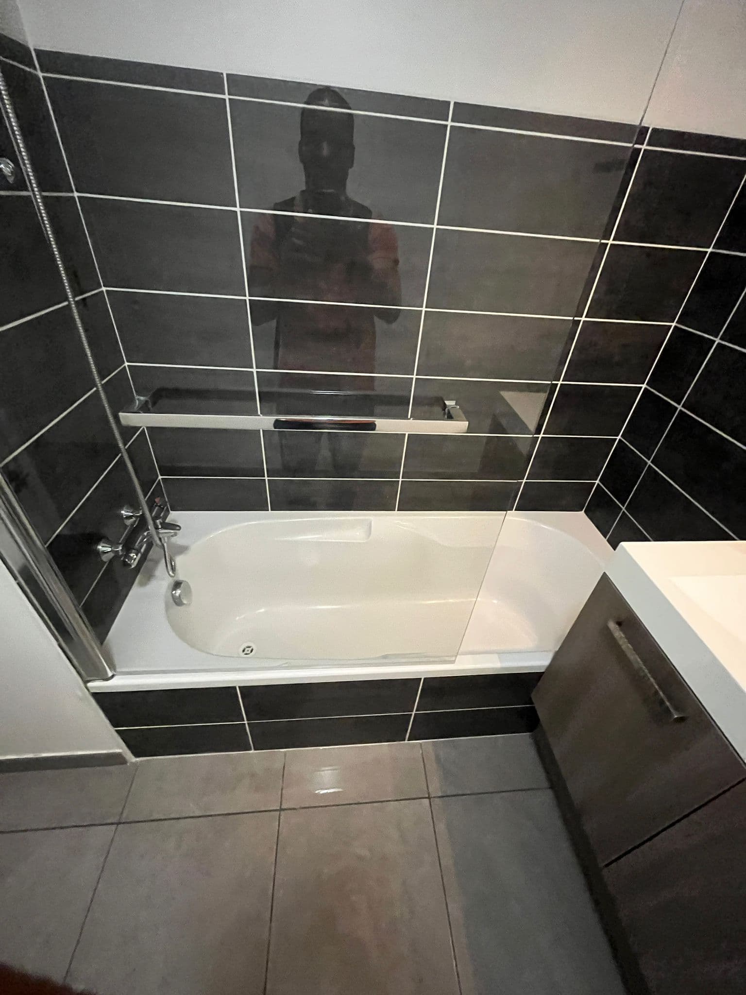 Baignoire avec paroi vitrée et robinetterie chromée